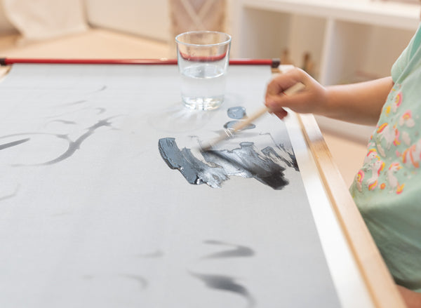 child drawing on reusable water drawing mat without mess